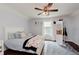 Bright bedroom with a queen bed, ceiling fan, dark wood flooring and closet near a window at 11074 Galley Way, Fishers, IN 46040