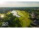 Aerial view of golf course, lake, and surrounding homes with mature trees at 12450 Petalon Trce, Fishers, IN 46037