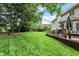 Spacious backyard featuring mature trees, lush green grass, and a large deck at 12450 Petalon Trce, Fishers, IN 46037