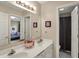 Bathroom featuring double sinks, vanity with framed mirror and views into a bedroom at 12450 Petalon Trce, Fishers, IN 46037