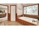 Bright bathroom with a jetted tub, wood trim, and decorative accents at 12450 Petalon Trce, Fishers, IN 46037