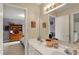Bathroom featuring double sinks, framed mirrors and views into a bedroom at 12450 Petalon Trce, Fishers, IN 46037