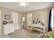 Bedroom featuring a white vanity and seat adjacent to wall art and window with blackout curtains at 12450 Petalon Trce, Fishers, IN 46037