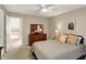 Neutral bedroom with ceiling fan, complemented by an ornate mirror and artwork at 12450 Petalon Trce, Fishers, IN 46037