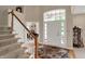 Bright foyer boasts hardwood floors, staircase and view into the home office at 12450 Petalon Trce, Fishers, IN 46037