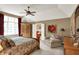 Spacious main bedroom with a ceiling fan, chair and large window at 12450 Petalon Trce, Fishers, IN 46037