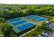 Aerial view of tennis courts with players, a building, trees, and parked cars at 12450 Petalon Trce, Fishers, IN 46037