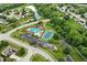 An aerial view showcasing the community pool, tennis courts, basketball court, and pond in a desirable neighborhood at 13757 Flintridge Pass, Carmel, IN 46033