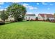 Expansive backyard with lush green lawn, mature trees, and a wooden fence at 13757 Flintridge Pass, Carmel, IN 46033