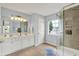 Bright bathroom with a double sink vanity, a window, and a glass-enclosed shower with tiled niches at 13757 Flintridge Pass, Carmel, IN 46033