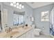 Bathroom with double sinks, a toilet, and a shower with a floral curtain at 13757 Flintridge Pass, Carmel, IN 46033