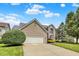 Beautiful two-story brick home with an attached two-car garage, manicured lawn, and mature trees under blue skies at 13757 Flintridge Pass, Carmel, IN 46033