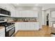 Kitchen featuring white cabinets, stainless steel appliances, and mosaic backsplash at 13757 Flintridge Pass, Carmel, IN 46033