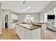 Kitchen island with sink and additional seating, offering an open view to the living room at 13757 Flintridge Pass, Carmel, IN 46033