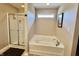 Bright bathroom featuring a glass enclosed shower and a soaking tub below a window at 13859 Keams Dr, Fishers, IN 46038