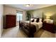 Bedroom with a four-poster bed, a large houseplant, and dark wood furniture at 13859 Keams Dr, Fishers, IN 46038