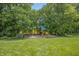Spacious backyard features a playground with slide and swing set amidst lush greenery and mature trees at 1393 Turfway Dr, Avon, IN 46123