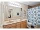 Bathroom with double sink vanity, decorative mirror, and blue patterned shower curtain create relaxing atmosphere at 1393 Turfway Dr, Avon, IN 46123