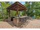 Outdoor kitchen bar area with stone counter and bar stool seating at 1393 Turfway Dr, Avon, IN 46123