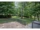 Lush backyard view from the wooden deck, showcasing a serene wooded area and well-maintained lawn at 14407 Bryn Mawr Dr, Fishers, IN 46038