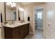 Well-lit bathroom boasts a double sink vanity with wood cabinetry and a doorway to a shower and bath combo at 14407 Bryn Mawr Dr, Fishers, IN 46038
