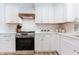 Close up of white cabinets, subway tile backsplash, range and vent hood in updated kitchen at 14407 Bryn Mawr Dr, Fishers, IN 46038