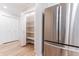 Pantry and stainless steel refrigerator in updated kitchen with white shaker cabinets and new flooring at 14407 Bryn Mawr Dr, Fishers, IN 46038