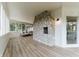 Sunroom with light hardwood floors features a floor to ceiling stone fireplace and large windows at 14407 Bryn Mawr Dr, Fishers, IN 46038