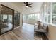 Light filled sunroom has many windows, wood flooring, sliding glass doors and contemporary furnishings at 14407 Bryn Mawr Dr, Fishers, IN 46038