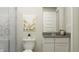 Neutral bathroom with a toilet, vanity, and shower and featuring gray countertops and modern fixtures, creating a clean look at 15389 Manderley St, Fishers, IN 46040