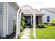 Lovely backyard featuring a white arbor, lush landscaping, and a stone pathway leading to a covered patio at 1580 Mairn Ave, Carmel, IN 46032