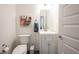 A half bath with a sink vanity, toilet, and decorative artwork at 1580 Mairn Ave, Carmel, IN 46032
