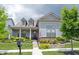 Charming home with inviting front porch, lush landscaping, and an American flag at 1580 Mairn Ave, Carmel, IN 46032