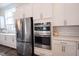 Gourmet kitchen features stainless steel appliances, built in oven, quartz countertops, tile backsplash and ample cabinet space at 1580 Mairn Ave, Carmel, IN 46032