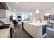 Modern kitchen boasts stainless steel appliances, and a large center island with a view to the living space at 1580 Mairn Ave, Carmel, IN 46032