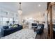 Bright living room with hardwood floors, stylish furnishings, chandelier and seamless flow to dining area and kitchen at 1580 Mairn Ave, Carmel, IN 46032