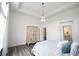 Comfortable bedroom showcasing neutral tones, tray ceiling, decorative armoire, and convenient access to an ensuite bathroom at 1580 Mairn Ave, Carmel, IN 46032