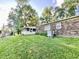 Exterior view of a brick home with a screened-in porch and a lush green lawn at 15841 E 265 N, Columbus, IN 47203