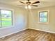 Bright bedroom with hardwood floors, ceiling fan, and views from two windows at 15841 E 265 N, Columbus, IN 47203