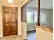 Foyer with a striking wood door, staircase columns and tiled flooring; bright natural light at 15841 E 265 N, Columbus, IN 47203