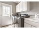 Well-equipped laundry room with modern washer and dryer, white cabinets, and access to the backyard at 15920 Oak Park Ct, Westfield, IN 46074