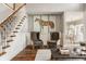 Inviting living room with a staircase and two armchairs below a horse painting above a hardwood floor at 15920 Oak Park Ct, Westfield, IN 46074