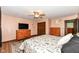 Well-lit bedroom with a ceiling fan, hardwood floors, large dresser and open entry doorway at 1624 Riley Rd, Lebanon, IN 46052