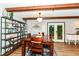 Bright dining area with exposed beams, wood floors, and a decorative shelving unit at 1624 Riley Rd, Lebanon, IN 46052