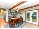 Inviting dining room features exposed wood beams, stylish shelving, and access to the deck at 1624 Riley Rd, Lebanon, IN 46052