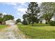 Expansive property with home, long driveway, lush lawn, mature trees, and a detached garage for ample parking and storage at 1624 Riley Rd, Lebanon, IN 46052