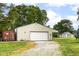 Exterior view of a spacious garage featuring a large door and green yard surroundings at 1624 Riley Rd, Lebanon, IN 46052