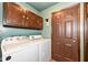 Functional laundry room with overhead cabinets, a door to the backyard, and washer/dryer at 1624 Riley Rd, Lebanon, IN 46052