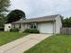 View of the front of the house, highlighting the attached garage and concrete driveway in a well-maintained yard at 1816 Hemlock Ln, Plainfield, IN 46168