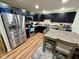 Modern kitchen featuring stainless steel appliances, dark cabinetry, and a dining area with seating at 1816 Hemlock Ln, Plainfield, IN 46168